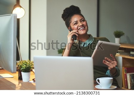 I must tell you...these designs are great. Shot of an attractive young woman using her cellphone and tablet in the office.