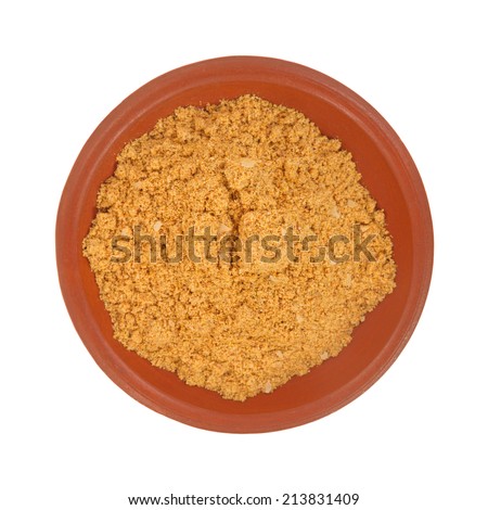 Top view of a portion of the seasonings used for making tacos in a small red bowl atop a white background.
