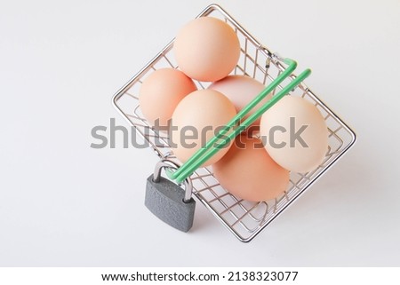Ban on the sale of chicken eggs. Food sanctions. Basket with groceries and a closed lock. Closed food warehouse. Lack of food.