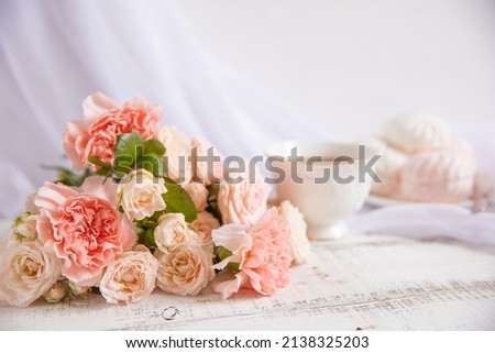 spring still life, a bouquet of roses in a vase, a cup of tea . spring greeting card with spring flowers