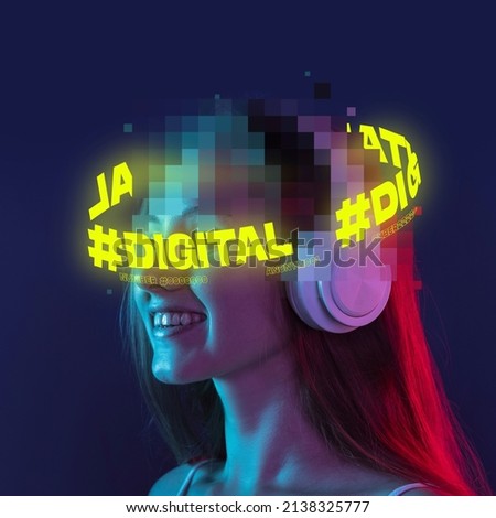 Young smiling woman with pixel head elements and neon lettering around listening to music in headphones over dark blue background. Concept of digitalization, artificial intelligence, technology era