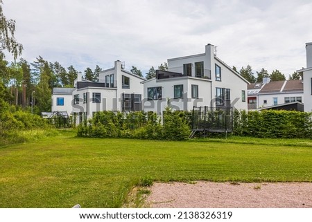 Beautiful view of white modern village houses on outskirts of village. Sweden. Royalty-Free Stock Photo #2138326319