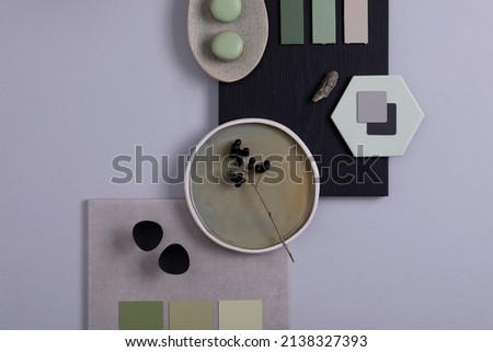 Stylish architect and interior designer moodboard. Flat lay composition in grey and green color palette with textile and paint samples, panels and tiles. Top view. Copy space. Template.