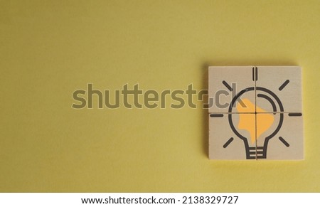 Creativity and inspiration ideas concept.,Light bulb icon on wooden cube over light yellow background on right corner with copyspace for put text or logo.	

