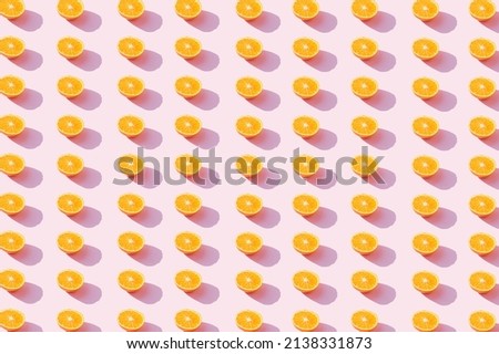 A pattern made of oranges fruit on a pink background. Aesthetic tropical fruit concept.