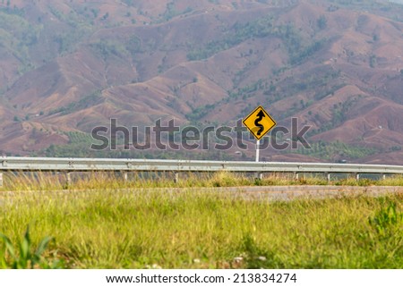 Road curve warning sign on rural area in Northeast of Thailand 