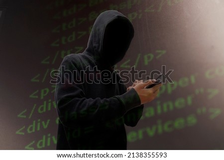 Computer hacker in mask and hoodie over abstract Data thief background.