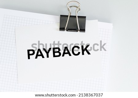 PAYBACK text on the card clip to the notepad on the table