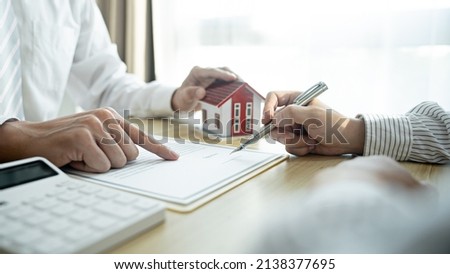 Home loan insurance. 
Real estate broker and client  sign contract insurance agreement document. Business meeting concept.