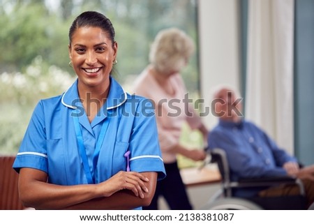 Portrait Of Female Nurse Or Care Worker Making Home Visit To Senior Couple With Man In Wheelchair Royalty-Free Stock Photo #2138381087