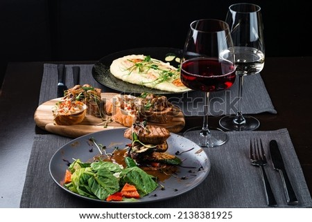 table set italian dinner in the restaurant. Top view of various Italian dishes with red and white wine Royalty-Free Stock Photo #2138381925