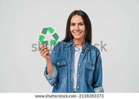 Young caucasian woman girl eco-activist holding recycling logo sign for sorting garbage paper plastic, environmental conservation saving planet from contamination, renewable energy sources Royalty-Free Stock Photo #2138383373