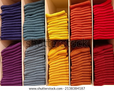 Socks are organized into categories by separate colors and stacked in an orderly fashion. Product placement concept for easy shopping for customers.