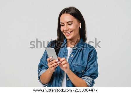 Smiling caucasian young woman listening to the podcast e-book music song singer rock band in earphones, choosing sound track on cellphone isolated in white background Royalty-Free Stock Photo #2138384477