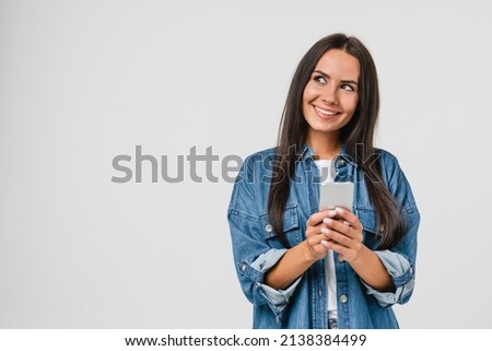 Dreamy thoughtful pensive caucasian young woman girl using smart phone cellphone for e-learning, e-commerce, e-banking online, mobile applications, making bet in casino isolated in white background