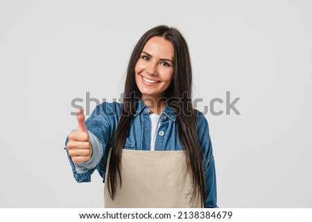 Smiling confident caucasian female woman barista bar tender in apron selling coffee tea hot beverage showing thumb up isolated in white background. Takeaway food. Royalty-Free Stock Photo #2138384679