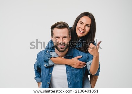 Young happy caucasian couple spouses girlfriend and boyfriend doing piggyback, dating, sharing love and passion showing thumb up isolated in white background Royalty-Free Stock Photo #2138401851