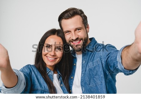 Young smiling caucasian couple boyfriend and girlfriend dating taking selfie photo together looking at camera, blogging vlogging for social media networks isolated in white background