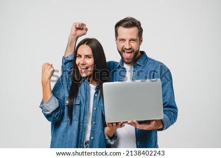 Success winning victory. Happy caucasian young couple spouses man and woman feeling excited after gambling, online casino, bet on laptop, winning money in lottery isolated in white Royalty-Free Stock Photo #2138402243