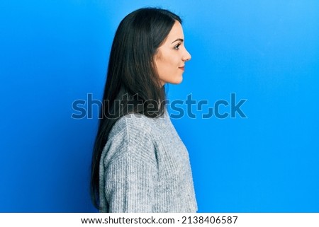 Young hispanic woman wearing casual clothes looking to side, relax profile pose with natural face and confident smile. 