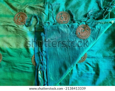 Stock photo of Designer beautiful sea green nursery color shade silk saree with golden color round shape peacock design on it. Picture captured under natural light at Bangalore, Karnataka, India.