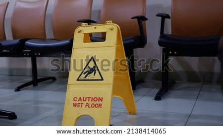yellow caution wet floor sign on a waiting room area in a hospital. Jakarta, 23 march 2022.