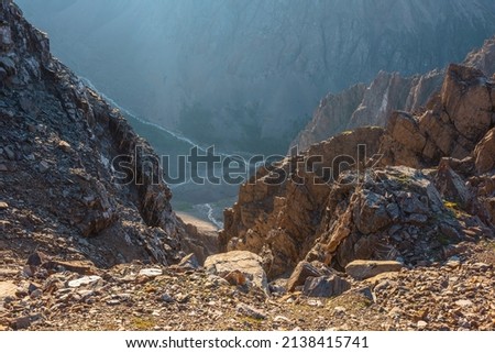 Awesome mountain view from cliff at very high altitude. Scenic landscape with beautiful sharp rocks near precipice and couloirs in sunlight. Beautiful mountain scenery on abyss edge with sharp stones. Royalty-Free Stock Photo #2138415741