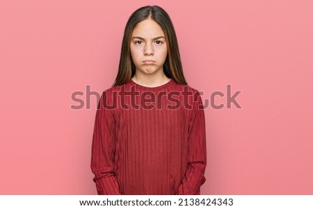 Beautiful brunette little girl wearing casual sweater depressed and worry for distress, crying angry and afraid. sad expression. 