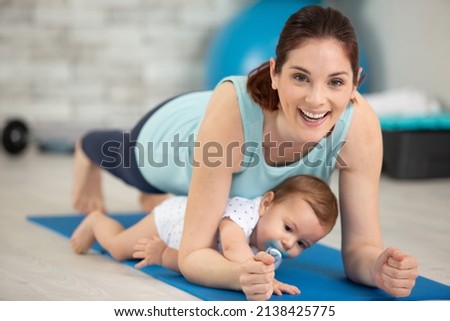 woman ane baby boy exercising on floor at home Royalty-Free Stock Photo #2138425775