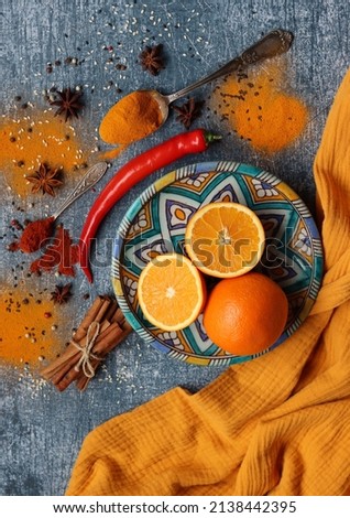 Oranges, red pepper, paprika powder, turmeric and anise top view photo. Spices on a table. Spicy meal preparation in process. Colorful still life with fruit. 