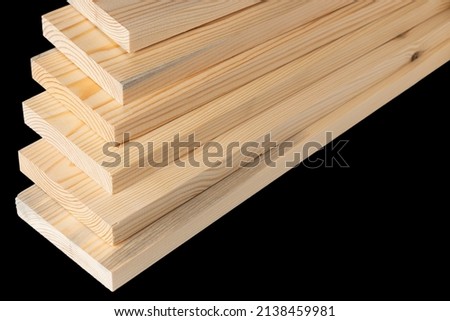 Wooden boards on black in a woodworking industry. stacks with pine lumber. folded edge board. timber for construction.