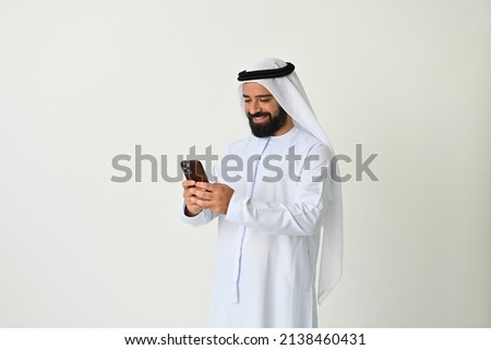 Arab Emirati man texting in UAE using mobile phone and sending or receiving messages maybe making a business call Royalty-Free Stock Photo #2138460431