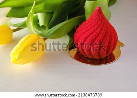 Red, bright dessert with yellow tulips on a white background.