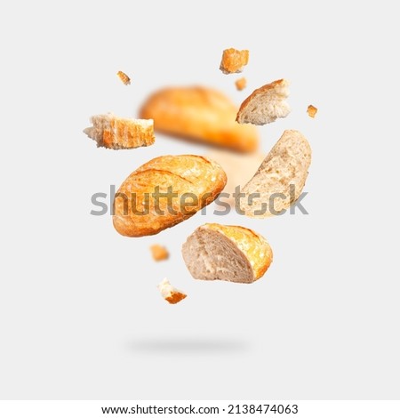 Classic white wheat bread flying on gray background. Round whole and pieces crispy fresh bread, healthy organic food, traditional pastries, bakery. Creative food concept for advertising, design  Royalty-Free Stock Photo #2138474063