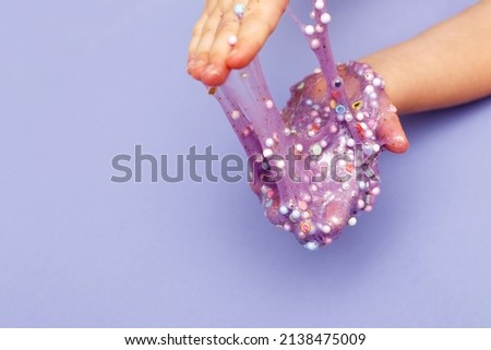 Making slime at home. child holding and stretching colorful slime. DIY concept Royalty-Free Stock Photo #2138475009