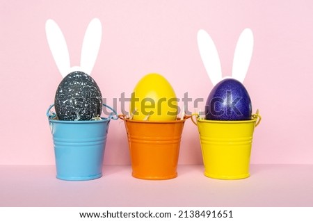 multi colors painted easter eggs in colored buckets with rabbit ears. Happy Easter Card	