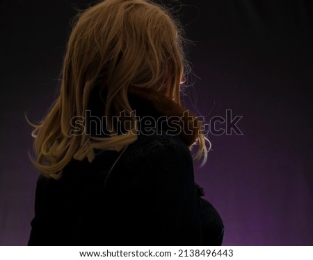 SIlhouette of blond hair woman with violet color background