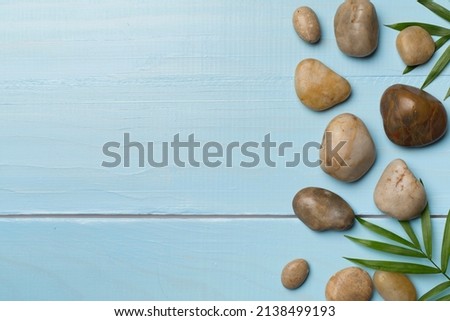 Spa stones and leaves on wooden background, top view.
