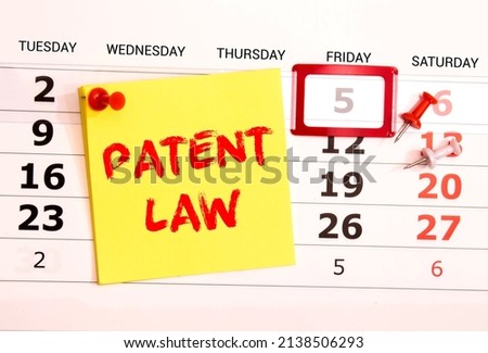 Business and law concept. Between two sheets of notebook on a red background the inscription - PATENT LAW,