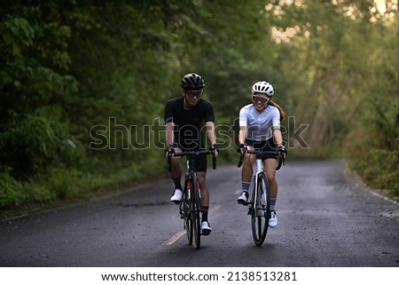 happy couple cycle or ride bicycle on rode in countryside for health life style Royalty-Free Stock Photo #2138513281