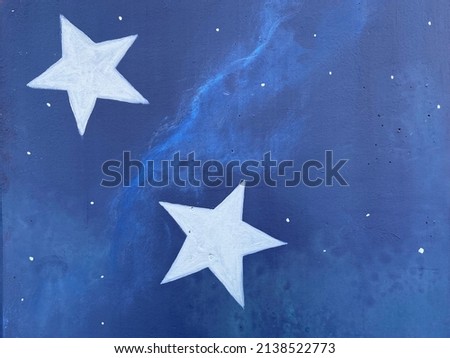 Two white stars painted against a blue-colored wall 