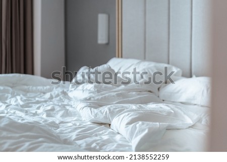 crumpled quilt and pillows on the bed  Royalty-Free Stock Photo #2138552259