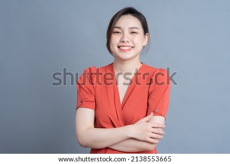 Young Asian woman posing on gray background Royalty-Free Stock Photo #2138553665