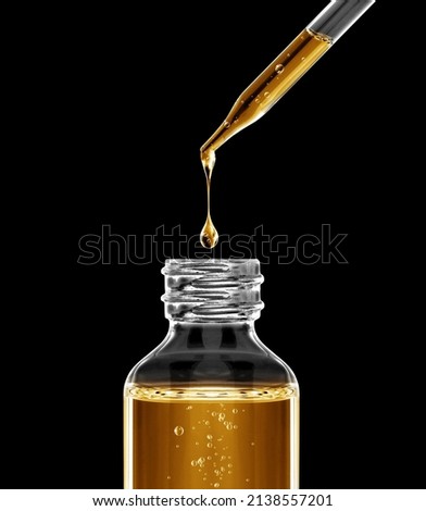 Stretched drop drips from the dropper into the bottle in the dark Royalty-Free Stock Photo #2138557201