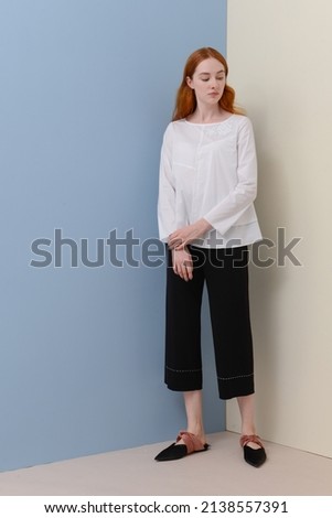Fashion model Posed on beige and blue background in fashion clothes 


