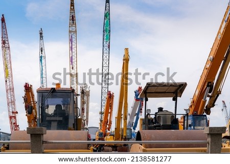 Road roller, mobile crane, and backhoe with long boom. Heavy machinery parked at second-hand machinery auction yard. Road roller, mobile crane, and digger for rent and sale. Construction industry. Royalty-Free Stock Photo #2138581277