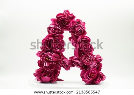 The letter A is made of burgundy flowers. Unique floral font. Summer, spring, autumn flowers