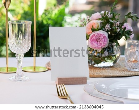 Mockup white blank space card, for greeting, table number, wedding invitation template on wedding table setting background. with clipping path Royalty-Free Stock Photo #2138604045