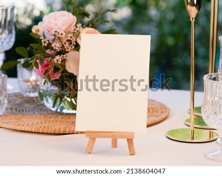 Mockup white blank space card, for greeting, table number, wedding invitation template on wedding table setting background. with clipping path Royalty-Free Stock Photo #2138604047