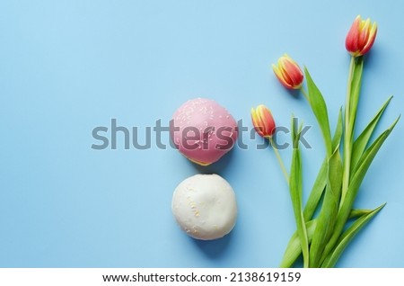 Morning with yellow, red tulips and sweet donuts on blue background. Top view, copy space, mockup. Flat lay. Food and drinks. Spring holidays. 